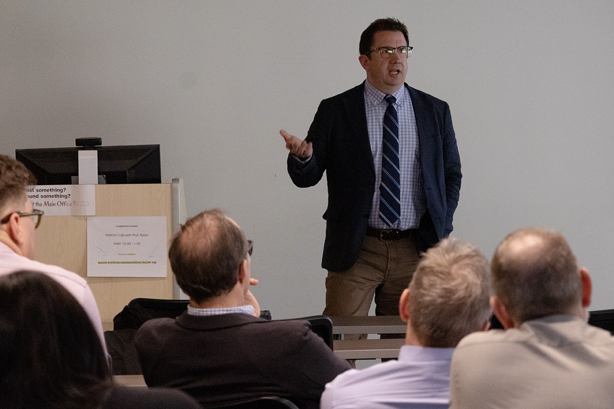 Joseph Uscinski lectures in front of a seated audience in a classroom.