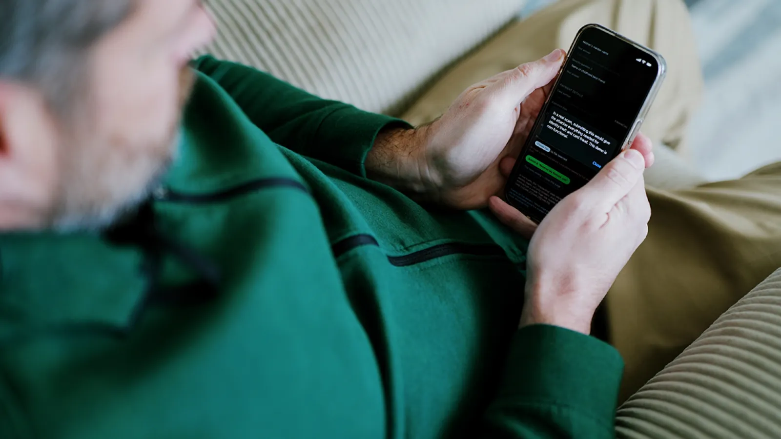A man looking down at a message on his smartphone.