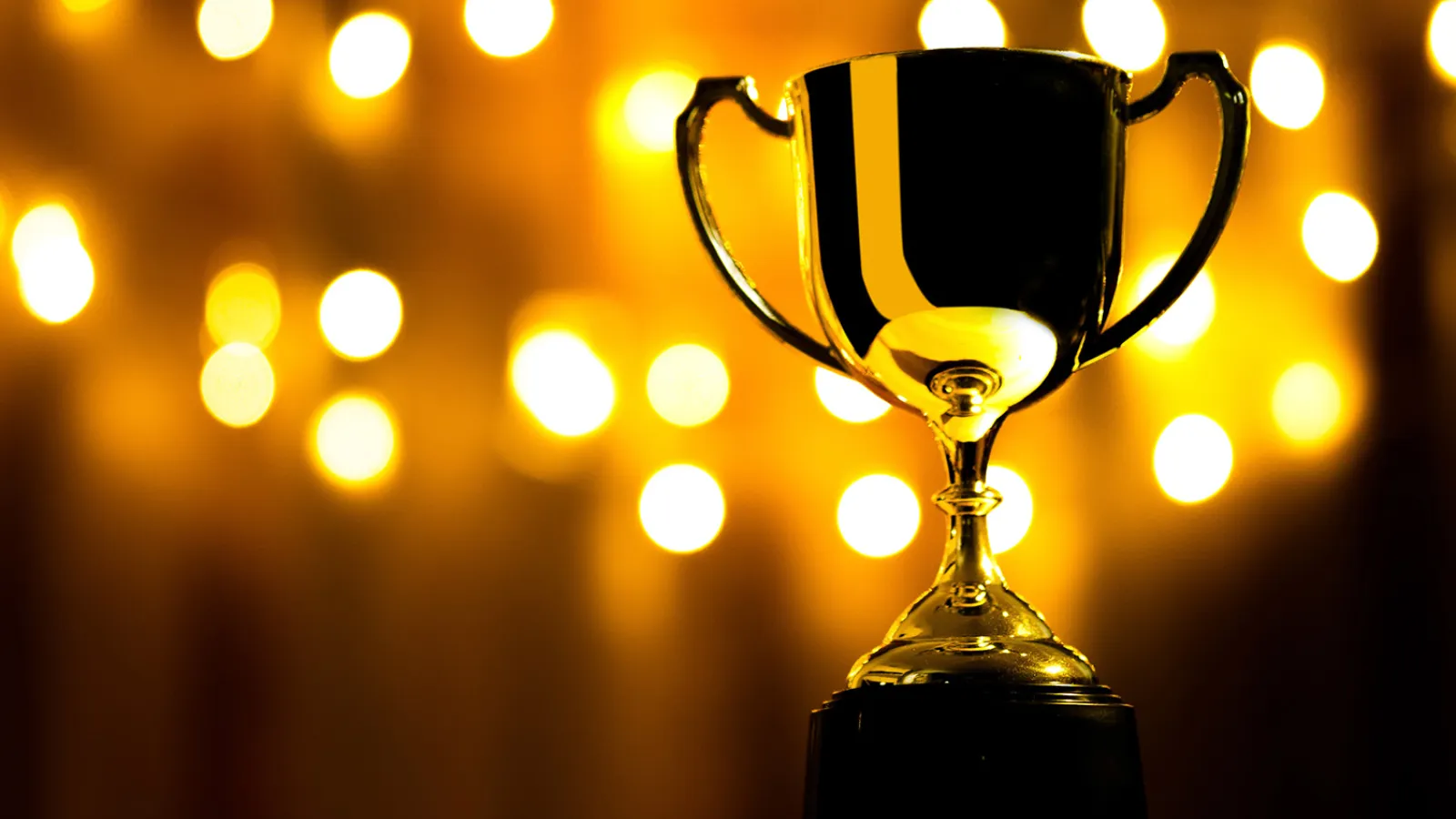 A golden trophy against a black and gold background