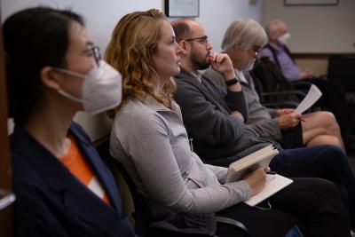 A row of people seated listening attentively to a presentation.