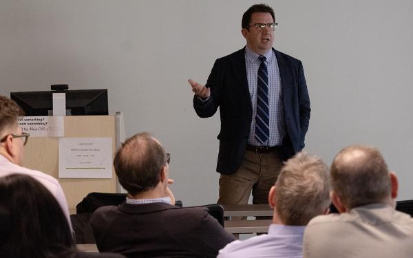 Joseph Uscinski lectures in front of a seated audience in a classroom.
