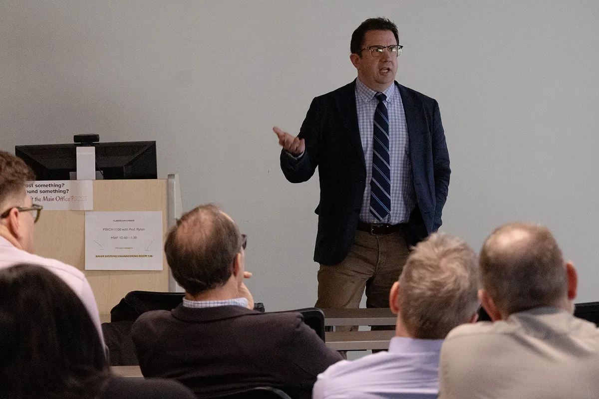 Joseph Uscinski lectures in front of a seated audience in a classroom.