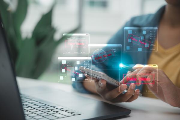 Windows identifying "fake news" pop up as a person scrolls through their smartphone